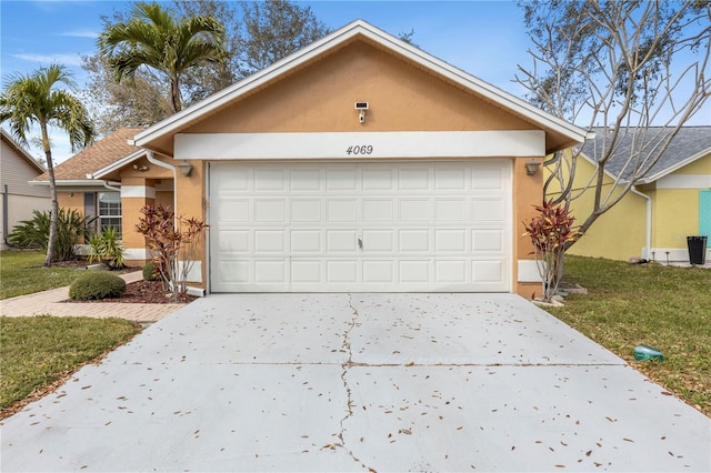 ranch-style home with a garage, driveway, a front yard, and stucco siding