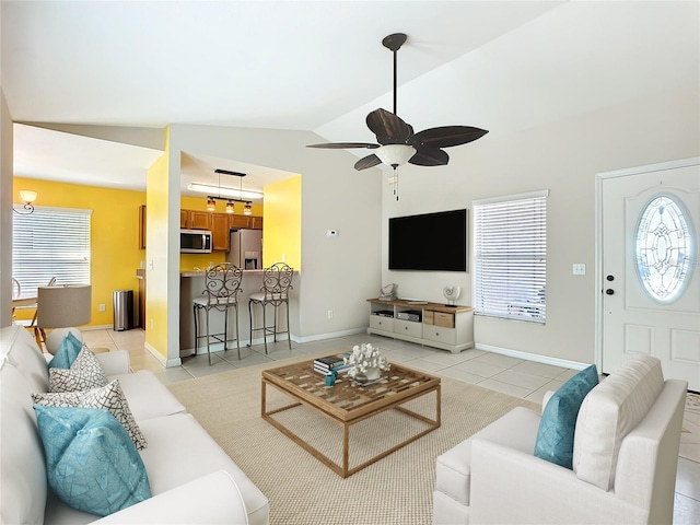 living room featuring a healthy amount of sunlight, light tile patterned floors, ceiling fan, and vaulted ceiling