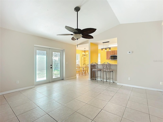 unfurnished living room featuring baseboards, lofted ceiling, ceiling fan with notable chandelier, french doors, and light tile patterned flooring