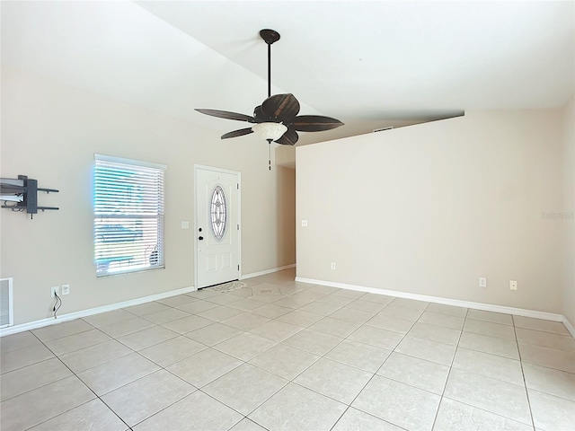 empty room featuring light tile patterned floors, lofted ceiling, visible vents, a ceiling fan, and baseboards