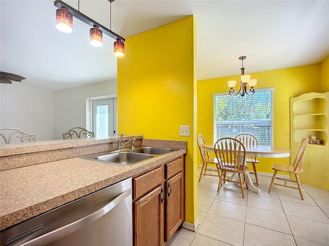 kitchen featuring a healthy amount of sunlight, decorative light fixtures, a sink, and dishwasher