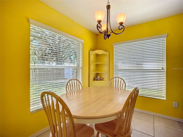 dining room featuring light tile patterned floors, baseboards, and an inviting chandelier