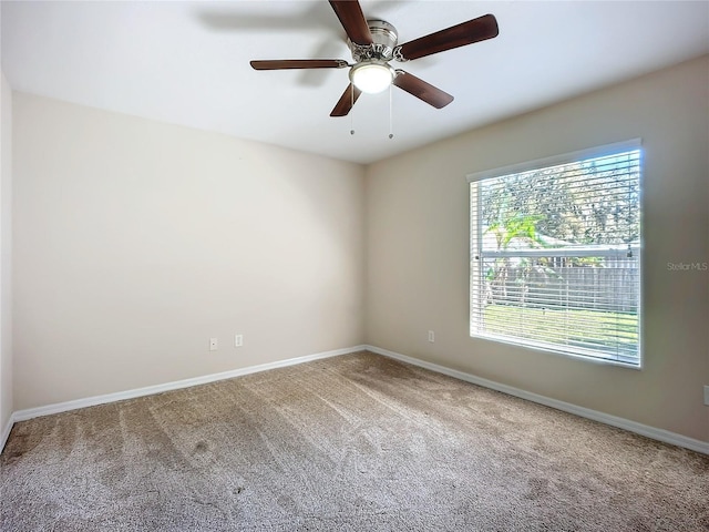 unfurnished room featuring carpet floors, baseboards, and a ceiling fan