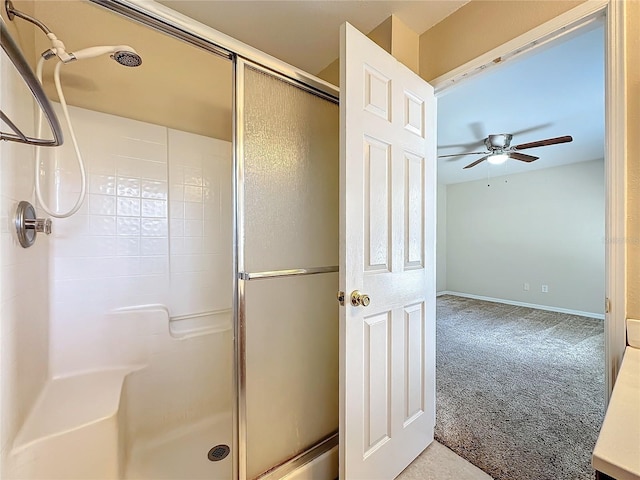 full bath featuring a stall shower, a ceiling fan, and baseboards