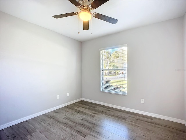 unfurnished room featuring ceiling fan, wood finished floors, and baseboards