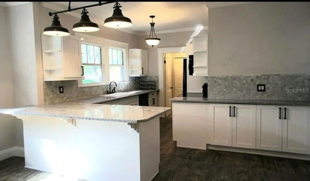 kitchen with a peninsula, white cabinetry, a kitchen breakfast bar, hanging light fixtures, and open shelves