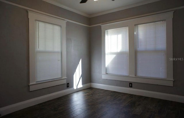 empty room featuring dark wood-style floors, baseboards, ornamental molding, and ceiling fan