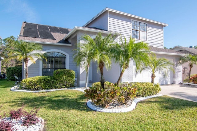 view of front of property with a garage, driveway, a front yard, and roof mounted solar panels