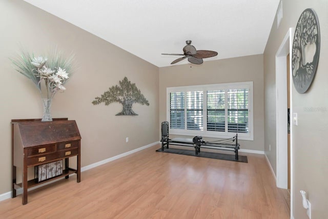 living area featuring baseboards, ceiling fan, visible vents, and light wood-style floors