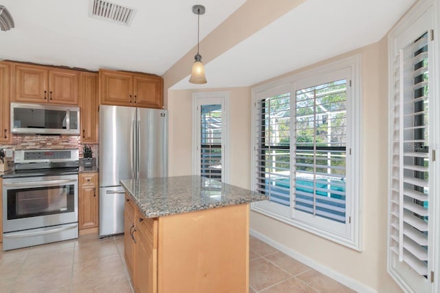 kitchen with light tile patterned floors, visible vents, light stone countertops, stainless steel appliances, and backsplash