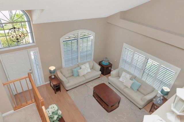 living area featuring baseboards, a chandelier, and wood finished floors