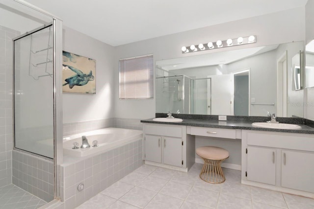 bathroom with a garden tub, double vanity, a stall shower, and a sink