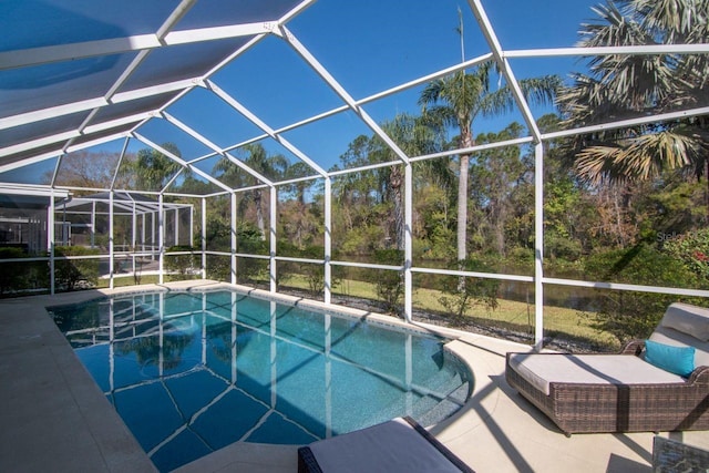 view of swimming pool with glass enclosure and a patio