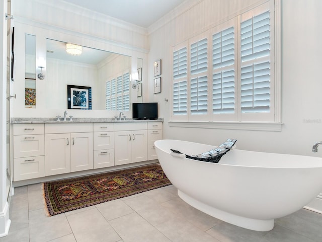 full bathroom with double vanity, a soaking tub, a sink, and crown molding