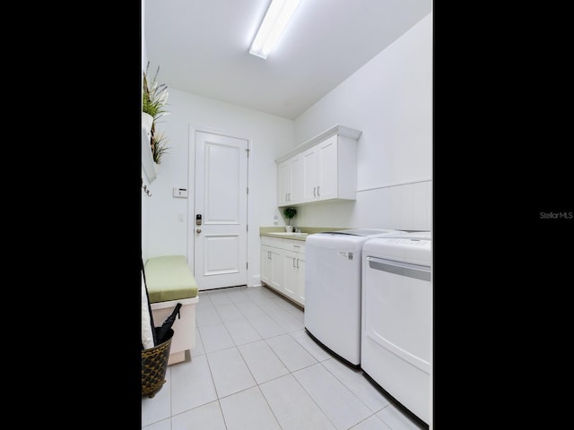 washroom featuring cabinet space, light tile patterned flooring, and independent washer and dryer