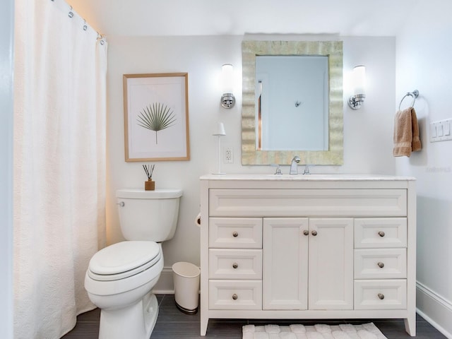 full bath with toilet, baseboards, and vanity