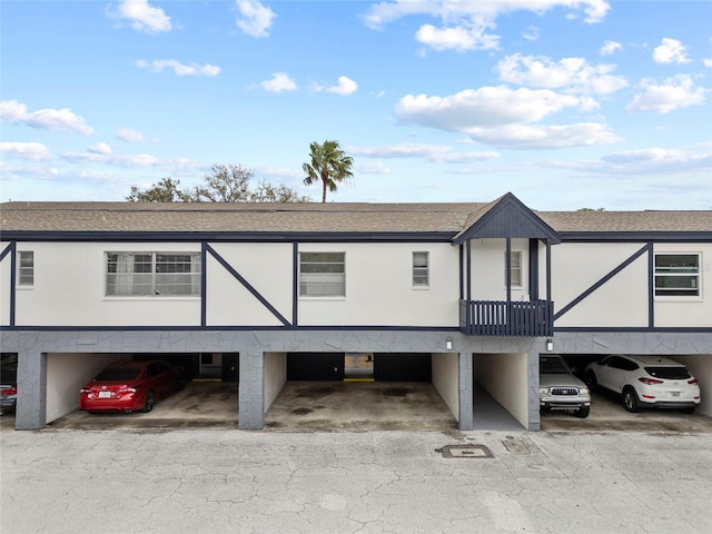 view of front of home featuring covered parking and a shingled roof