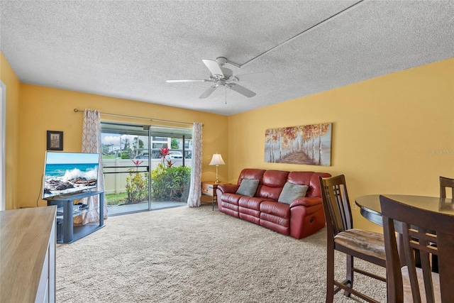 carpeted living room with ceiling fan and a textured ceiling