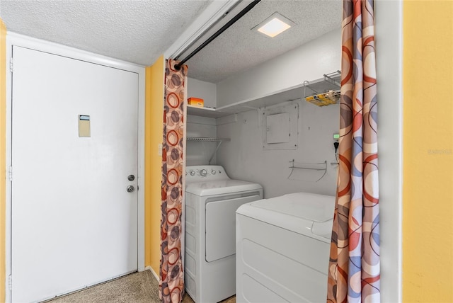 clothes washing area with laundry area, a textured ceiling, and washer and dryer