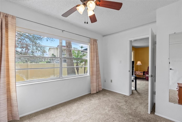 carpeted bedroom featuring a textured ceiling, a ceiling fan, and baseboards