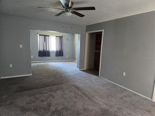 empty room featuring a ceiling fan, carpet, baseboards, and a textured ceiling