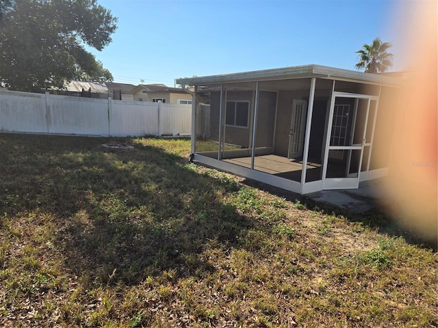 view of yard with fence and a sunroom