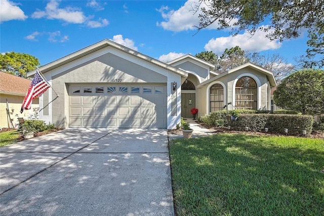 ranch-style home with a garage, a front yard, driveway, and stucco siding