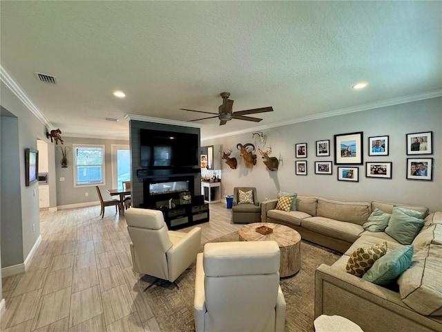 living room with baseboards, ornamental molding, and a textured ceiling