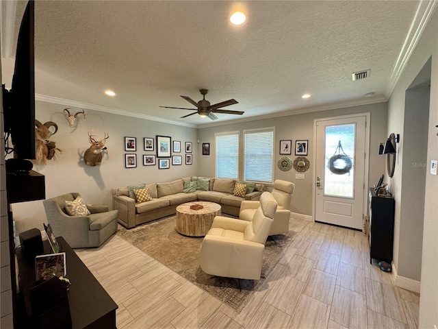 living area featuring a ceiling fan, a textured ceiling, visible vents, and crown molding