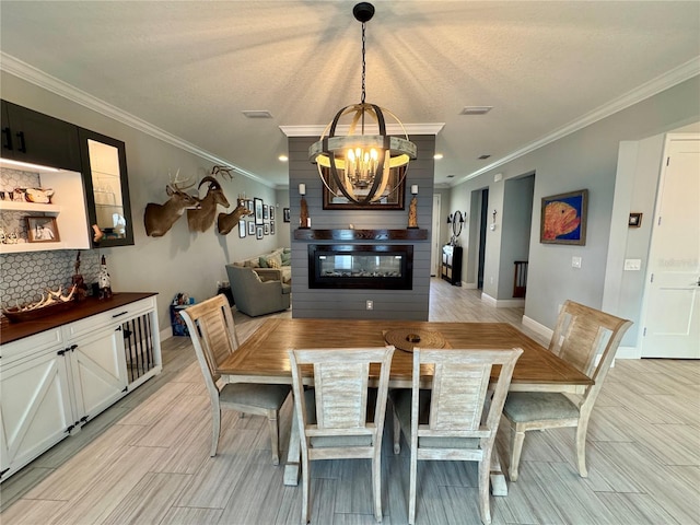 dining area featuring wood tiled floor, a large fireplace, a notable chandelier, and baseboards