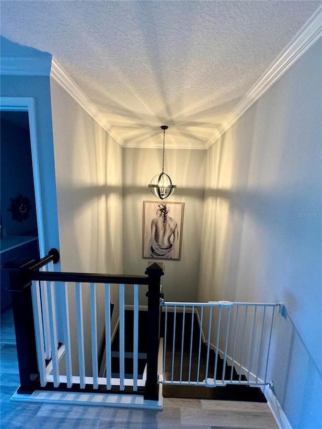 staircase featuring a textured ceiling and crown molding