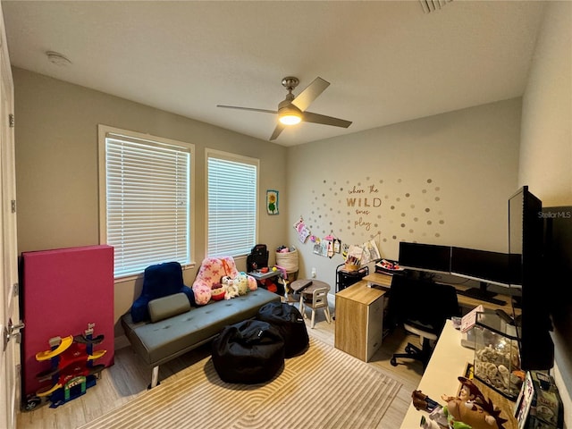 home office with ceiling fan and light wood-style flooring