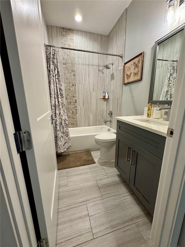 bathroom with shower / bath combo, vanity, and toilet