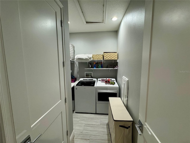 laundry area featuring washer and dryer, laundry area, and light wood finished floors