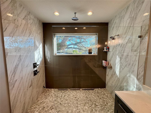 full bath with recessed lighting, tiled shower, and a textured ceiling