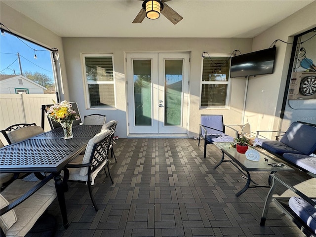 sunroom / solarium featuring french doors and a ceiling fan