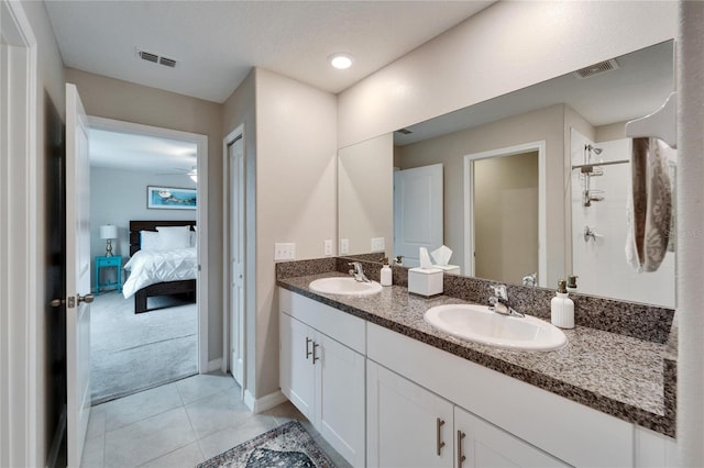 full bathroom featuring tiled shower, a sink, and visible vents