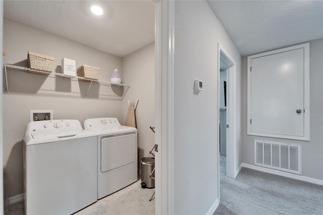 laundry area with washing machine and dryer, laundry area, visible vents, and a textured ceiling