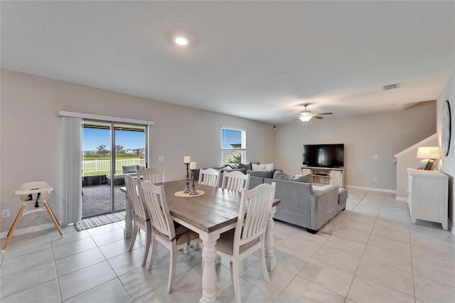 dining area featuring light tile patterned floors, ceiling fan, a textured ceiling, visible vents, and baseboards