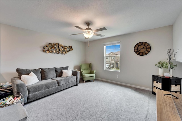 carpeted living room with ceiling fan, a textured ceiling, and baseboards