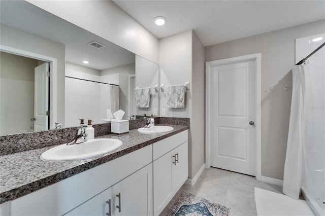 full bathroom featuring double vanity, a shower with curtain, visible vents, and a sink