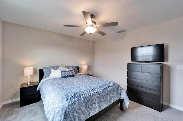 carpeted bedroom featuring baseboards, visible vents, and a ceiling fan