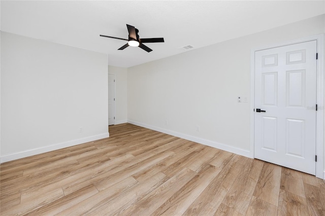 spare room with light wood-type flooring, visible vents, ceiling fan, and baseboards