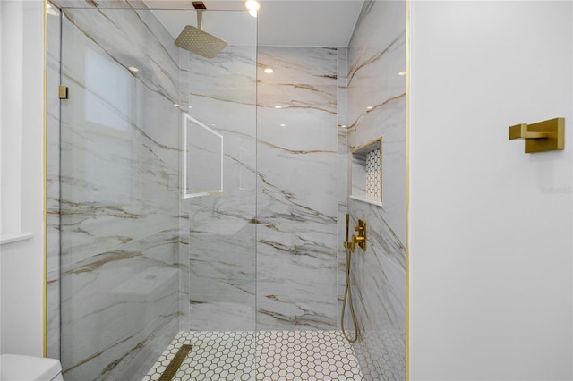 bathroom featuring a marble finish shower