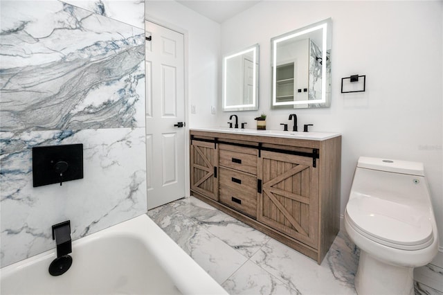 bathroom featuring a tub to relax in, marble finish floor, double vanity, toilet, and a sink