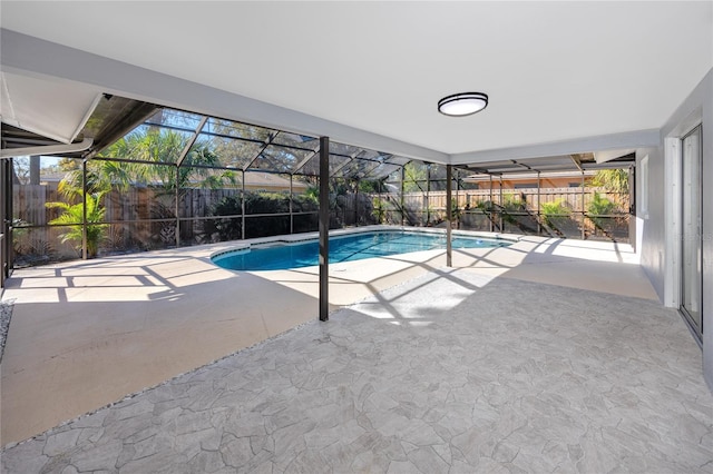 view of swimming pool with glass enclosure, a fenced backyard, a fenced in pool, and a patio