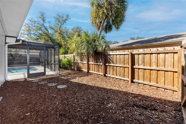 view of yard with glass enclosure, a fenced backyard, and a fenced in pool