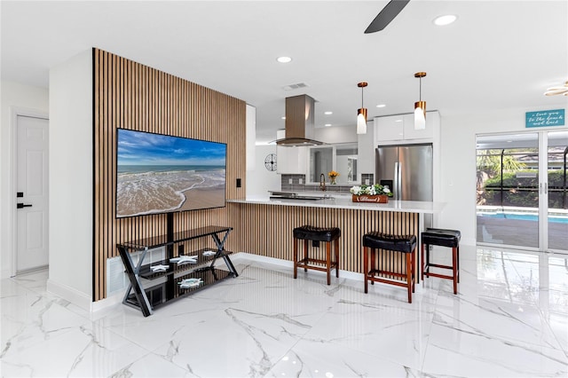 1100 Webb Dr, Clearwater, FL 33755 - kitchen with stainless steel refrigerator with ice dispenser, island range hood, recessed lighting, a peninsula, and light marble finish flooring