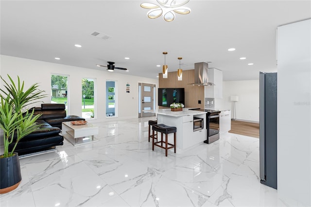 1100 Webb Dr, Clearwater, FL 33755 - kitchen featuring appliances with stainless steel finishes, wall chimney exhaust hood, modern cabinets, light countertops, and recessed lighting