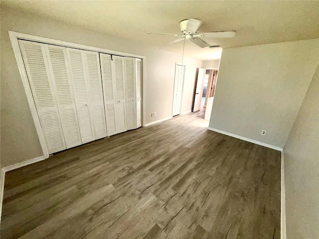 unfurnished bedroom featuring visible vents, a ceiling fan, baseboards, a closet, and dark wood finished floors